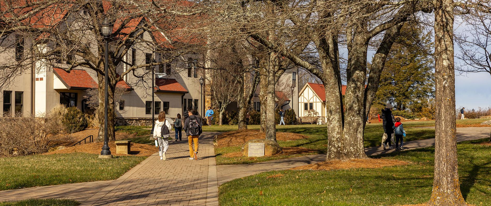 students walking outside on campus sidewalk